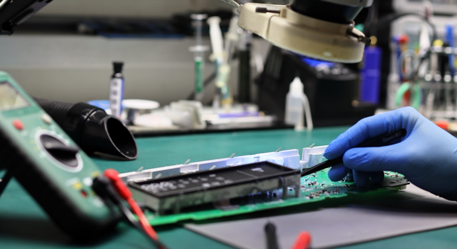 Werkstatt-Arbeitsplatz mit Mikroskop und Mainboard — KM Elektronik Xbox-Reparatur